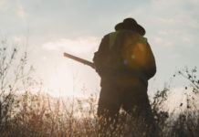 Approvato il calendario venatorio della Calabria calendario venatorio della calabria: cacciatore in alta visibilità di spalle con fucile