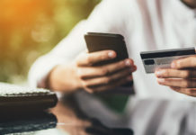 Pagamento della tassa regionale sulla caccia in Lombardia, la nota del Cuav Pagamento della tassa regionale sulla caccia in Lombardia: uomo con carta di credito e smartphone