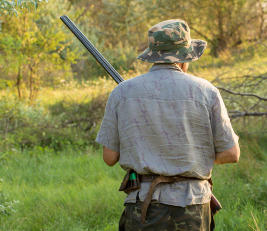 Caccia in Puglia: indiscrezione Federcaccia sulla sentenza del Tar caccia in puglia: cacciatore di spalle con cappello mimetico e fucile in mano