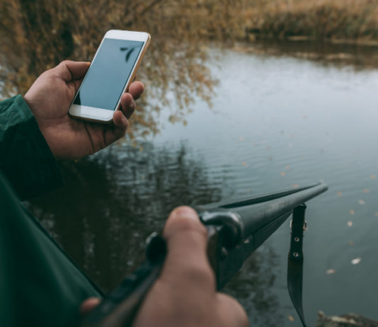Tesserino venatorio digitale, primi passi in Emilia Romagna cacciatore aggiorna tesserino venatorio digitale tenendo lo smartphone nella mano sinistra