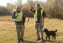 Calendario venatorio della Puglia: si torna davanti al Tar Calendario venatorio della Puglia: due cacciatori con gilet alta visibilità, fucile e fagiano in mano, cane al loro fianco