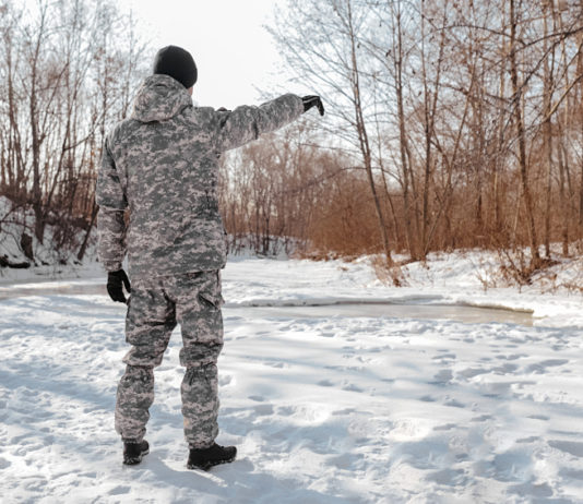 Sport invernali per cacciatori: l’evento in Alto Adige Sport invernali per cacciatori: cacciatore in abiti mimetici di spalle nella neve
