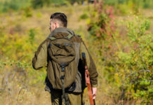 “Possibili effetti negativi sui prossimi calendari venatori”: allarme di CCT su nuove linee guida prossimi calendari venatori: cacciatore di spalle con fucile e zaino