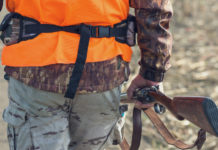 Calendario venatorio della Toscana, la Cct: “Non arretrare” Calendario venatorio della Toscana: cacciatore di spalle con gilet arancione, fucile nella mano destra