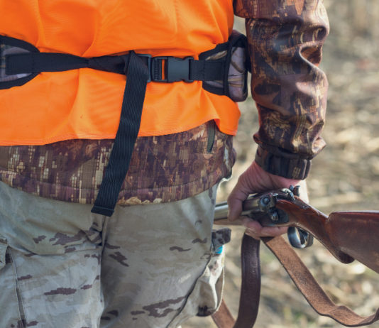 Calendario venatorio della Toscana, la Cct: “Non arretrare” Calendario venatorio della Toscana: cacciatore di spalle con gilet arancione, fucile nella mano destra