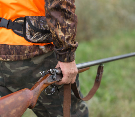 Approvato il calendario venatorio della Liguria per la stagione 2020/2021 calendario venatorio della Liguria: cacciatore con gilet alta visibilità e fucile nella mano destra