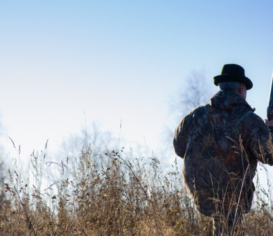 Caccia in Emilia Romagna: Bonaccini riapre Caccia in Emilia Romagna: cacciatore di spalle con zaino sulle spalle, cappello in testa e carabina nella mano destra
