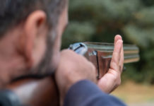 Caccia in Lombardia, da consiglio regionale ok alla riforma Caccia in Lombardia: cacciatore prende la mira per sparare, immagine da dietro