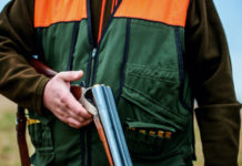 Cambia il modo di pagare la licenza di caccia in Piemonte pagare la licenza di caccia in Piemonte: cacciatore tiene in mano fucile aperto