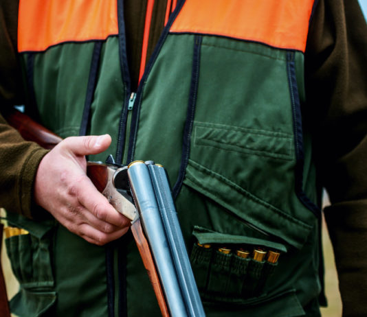 Cambia il modo di pagare la licenza di caccia in Piemonte pagare la licenza di caccia in Piemonte: cacciatore tiene in mano fucile aperto