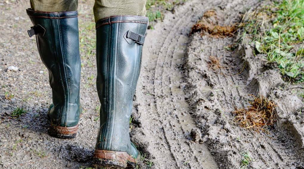 incidente di caccia: stivali di cacciatore che cammina su terreno fangoso