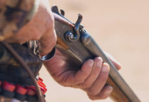 Calendario venatorio della Puglia, cacciatori protestano calendario venatorio della puglia: primo piano su mano di cacciatore che impugna fucile