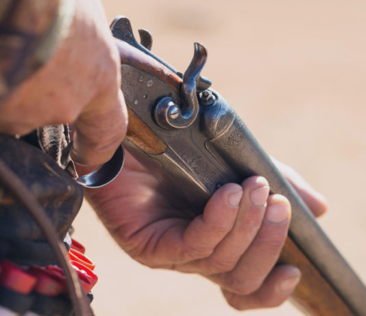 Calendario venatorio della Puglia, cacciatori protestano calendario venatorio della puglia: primo piano su mano di cacciatore che impugna fucile