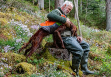 Nuova legge sulla caccia in Toscana, consiglio dice sì Nuova legge sulla caccia in Toscana: cacciatore seduto accarezza setter irlandese