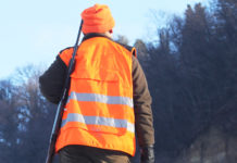 Dalla Liguria il primo protocollo sanitario per la braccata protocollo sanitario per la caccia in braccata: cacciatore in alta visibilità ritratto di spalle con fucile a tracolla