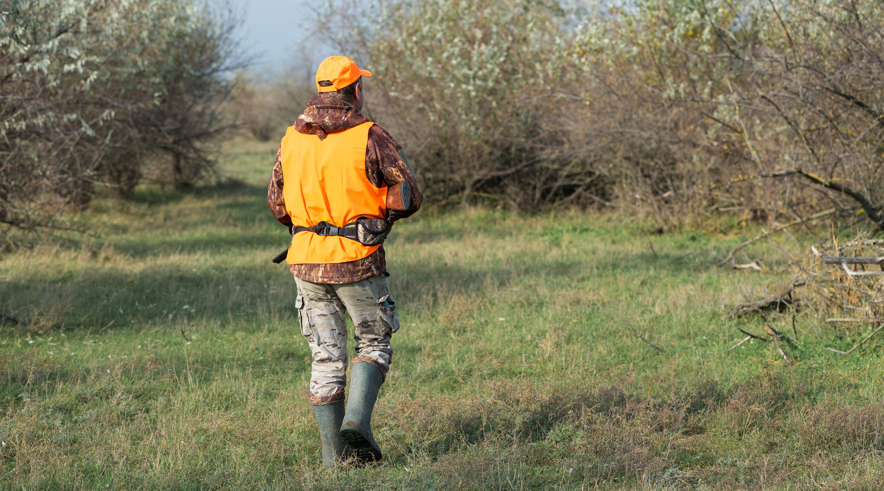 associazione unica dei cacciatori: cacciatore di spalle con gilet alta visibilità