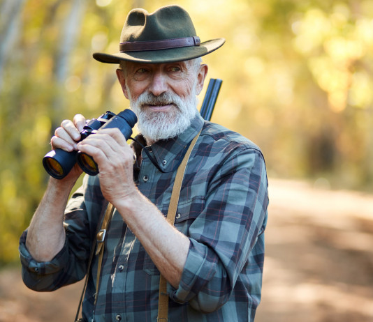 Caccia e conservazione: ecco il Manifesto per la biodiversità di Face caccia e conservazione: cacciatore anziano con binocolo tra le mani e fucile in spalla