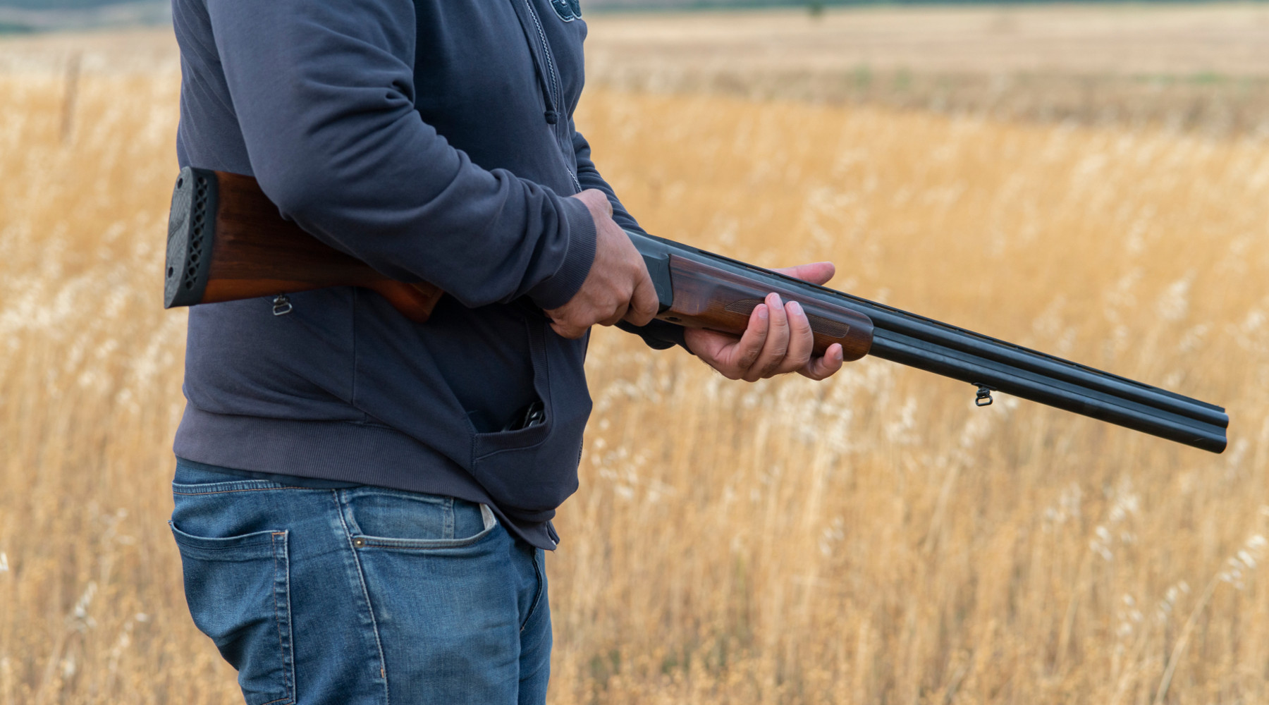 calendario venatorio della Toscana: cacciatore con fucile in campo di grano