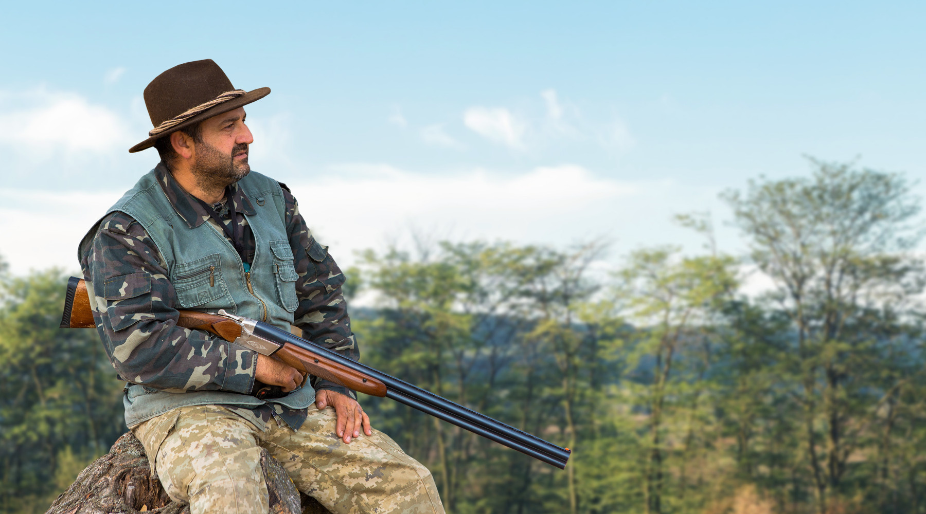 Riprende la stagione di caccia in Lombardia: cacciatore con fucile in posizione di riposo