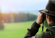 Referendum e legge sulla caccia: il commento della Libera Caccia Referendum e legge sulla caccia: cacciatrice di spalle con binocolo