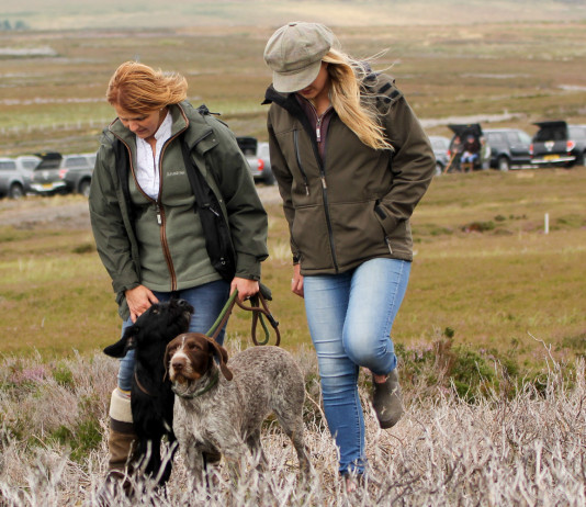 Trasportare i cani in automobile: viaggiamo sereni Trasportare i cani in automobile: cacciatori e cacciatrici con cane al guinzaglio, dopo esser scesi di macchina