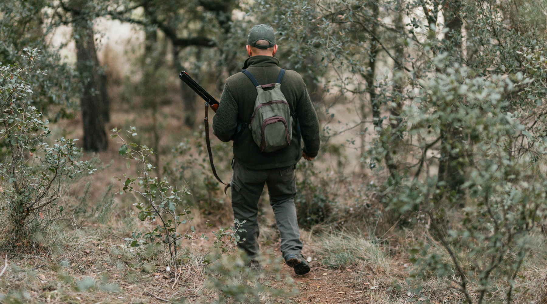 Calendario venatorio della Toscana: cacciatore di spalle nel bosco