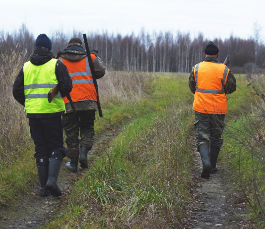 Calendario venatorio della Toscana 2022/2023: le anticipazioni Calendario venatorio della Toscana 2022-2023: tre cacciatori di spalle con gilet alta visibilità