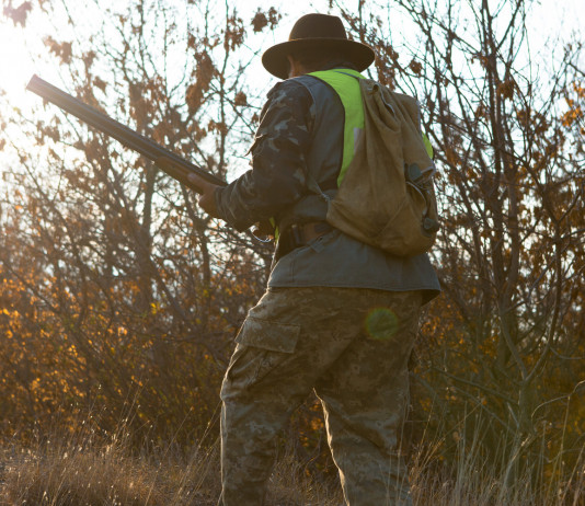 Scontro tra associazioni venatorie della Puglia Scontro tra associazioni venatorie della Puglia: cacciatore di spalle con gilet giallo alta visibilità