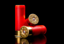 Munizioni in piombo: i prossimi passaggi Munizioni in piombo: tre cartucce da caccia con bossolo rosso e fondello ottonato su sfondo nero riflettente