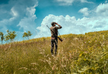 Competenza territoriale delle guardie venatorie volontarie, la sentenza del Tar Competenza territoriale delle guardie venatorie volontarie: giovane cacciatore di spalle, con fucile a tracolla, guarda l'orizzonte