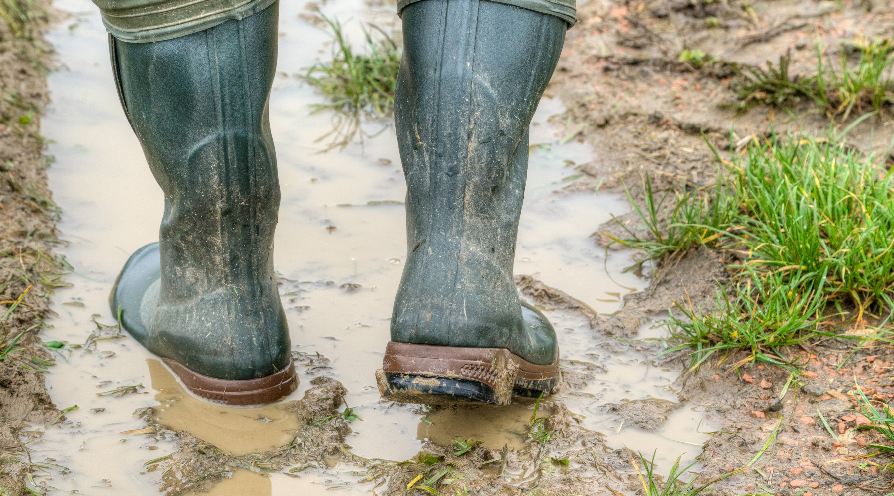 Emendamenti alla legge sulla caccia, il commento di Confagricoltura Emendamenti alla legge sulla caccia: primo piano su stivali di contadino nel fango