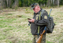 Ribaltata sentenza del Tar sulla rappresentanza dei cacciatori negli Atc Ribaltata sentenza del Tar sulla rappresentanza dei cacciatori negli Atc: cacciatore con fucile in spalla mentre guarda telefono