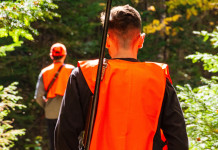 Cabina di regia: «Niente automatismo tra obiezione di coscienza e divieto di caccia nei fondi» Cabina di regia «Niente automatismo tra obiezione di coscienza e divieto di caccia nei fondi» - due giovani cacciatori di spalle, gilet arancione alta visibilità