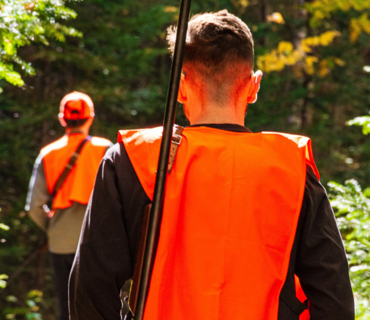 Cabina di regia: «Niente automatismo tra obiezione di coscienza e divieto di caccia nei fondi» Cabina di regia «Niente automatismo tra obiezione di coscienza e divieto di caccia nei fondi» - due giovani cacciatori di spalle, gilet arancione alta visibilità
